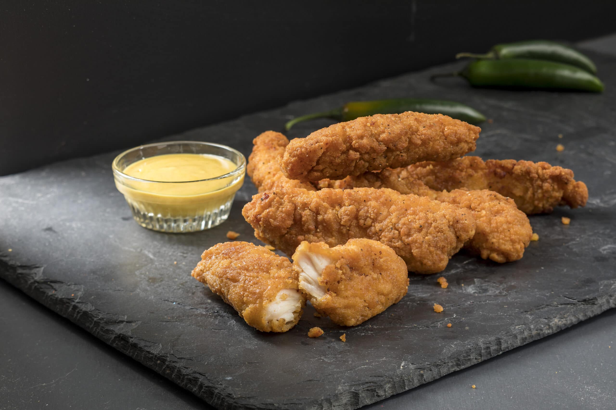 Chicken strips on a slate tray with honey mustard dipping sauce