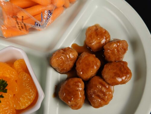 Chicken with hunan orange sauce on a white plate