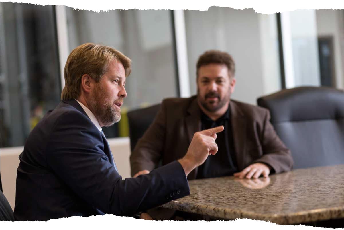 Mark and Michael speaking at a table