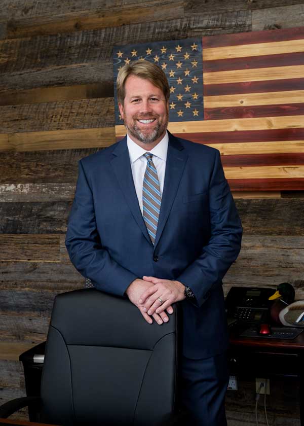 Mark Sosebee standing in front of a wooden wall